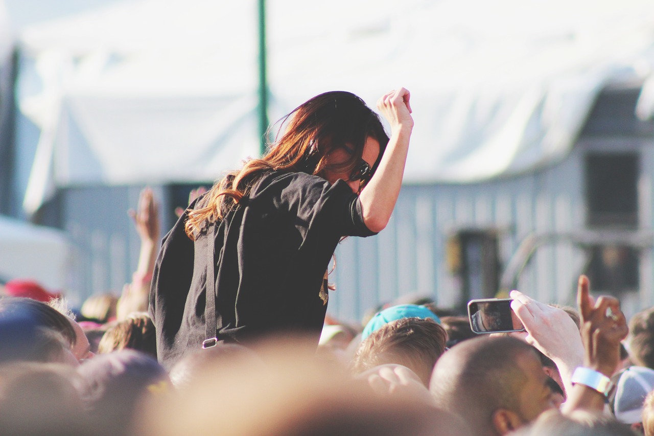 Woman with her hand in the air at a concert.